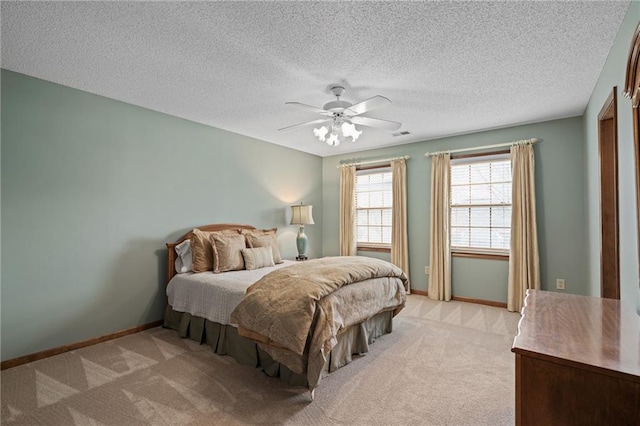 carpeted bedroom with ceiling fan and a textured ceiling