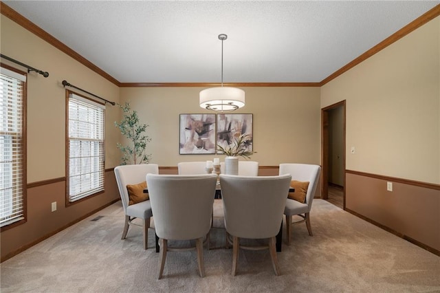 carpeted dining area with crown molding