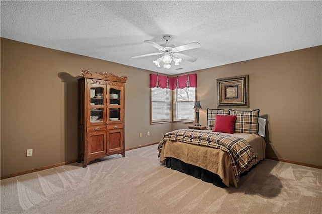 carpeted bedroom featuring ceiling fan and a textured ceiling