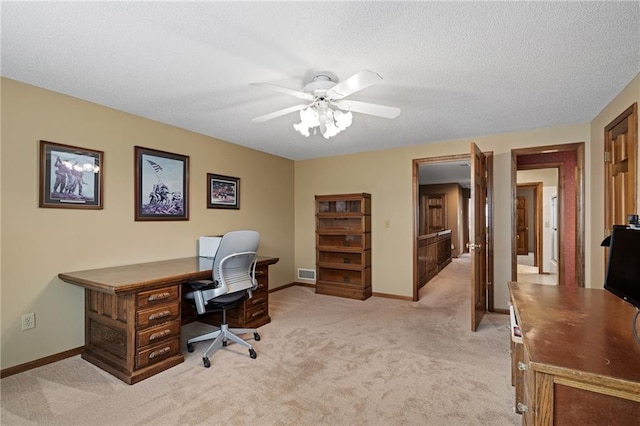 carpeted office space featuring a textured ceiling and ceiling fan