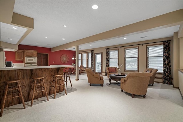 carpeted living room featuring ornate columns