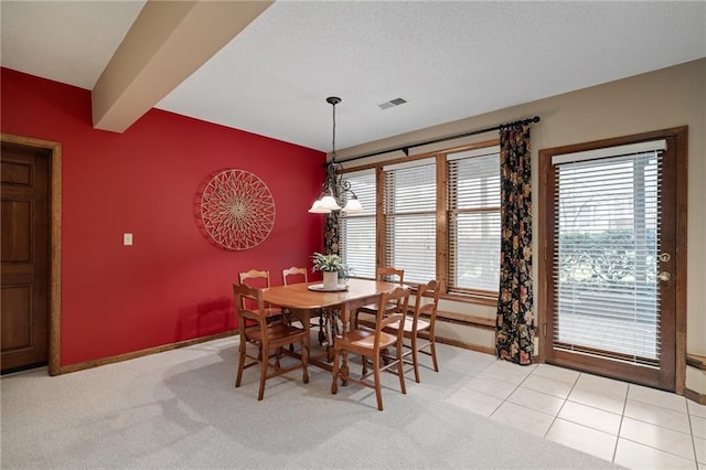 carpeted dining room with beamed ceiling