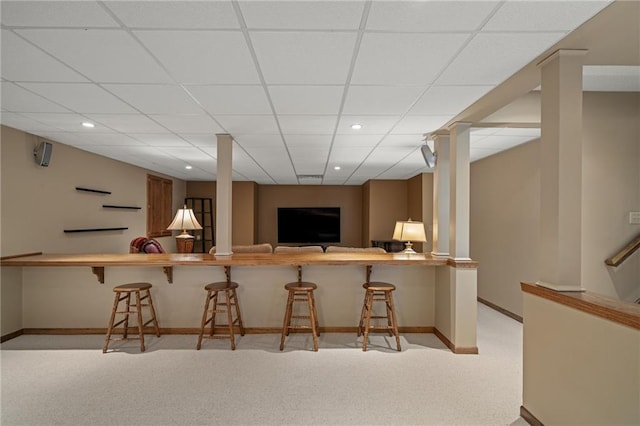 bar featuring a paneled ceiling and light carpet