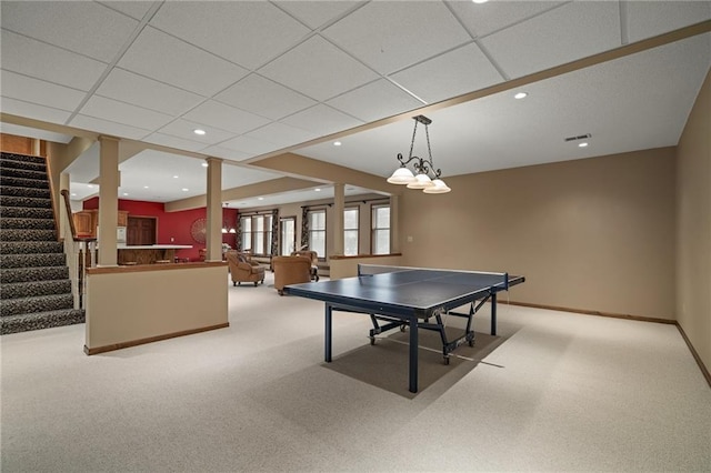 recreation room featuring a drop ceiling and light colored carpet