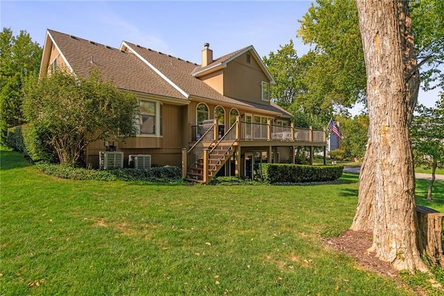 rear view of property with cooling unit, a deck, and a lawn