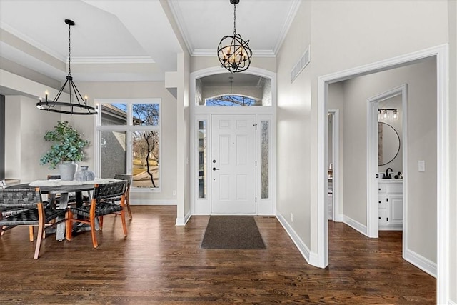 foyer with an inviting chandelier, ornamental molding, dark hardwood / wood-style floors, and sink