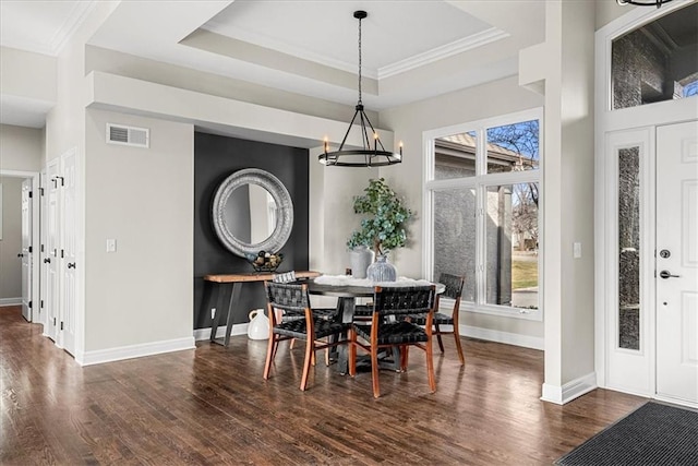 dining space with dark hardwood / wood-style flooring, a tray ceiling, and a healthy amount of sunlight