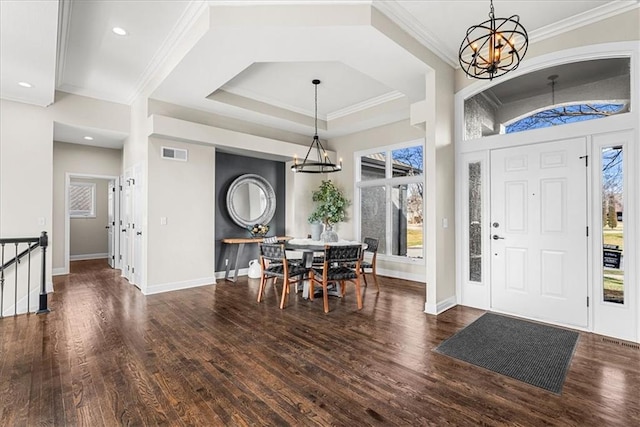 foyer entrance featuring dark hardwood / wood-style floors, a wealth of natural light, and an inviting chandelier