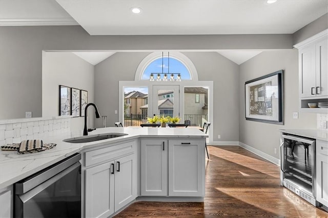 kitchen featuring wine cooler, sink, dishwasher, light stone countertops, and white cabinets