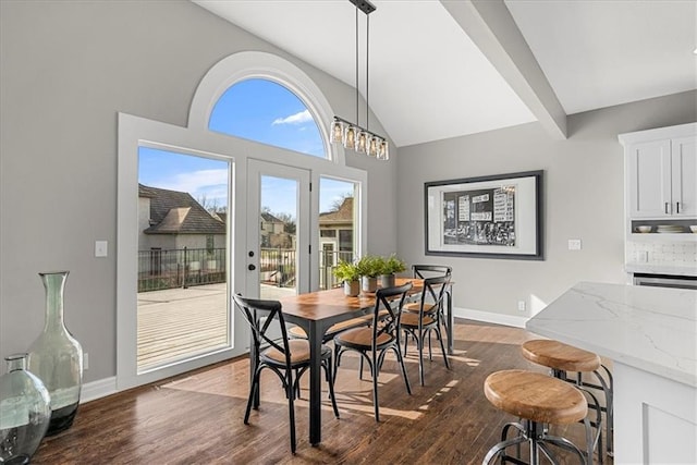 dining space featuring high vaulted ceiling and dark hardwood / wood-style flooring