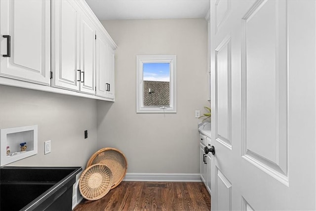 clothes washing area featuring electric dryer hookup, hookup for a washing machine, dark hardwood / wood-style floors, and cabinets