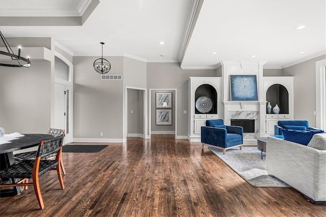 living room with ornamental molding, a premium fireplace, a chandelier, and hardwood / wood-style floors