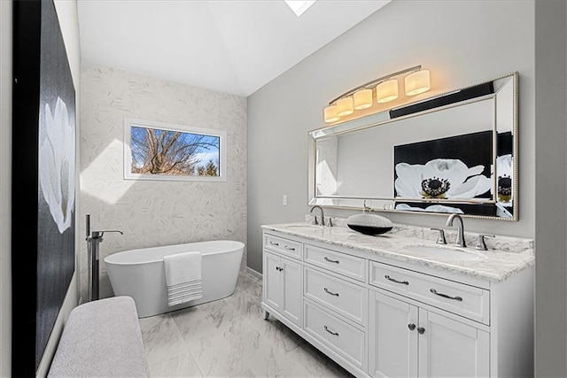 bathroom with vanity, vaulted ceiling, and a tub