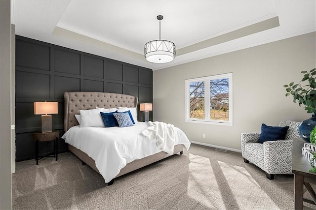 bedroom with crown molding, a tray ceiling, and carpet floors