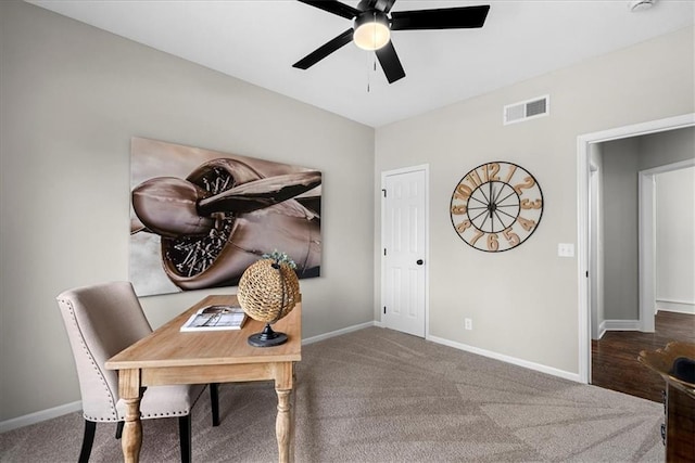 carpeted office space featuring ceiling fan