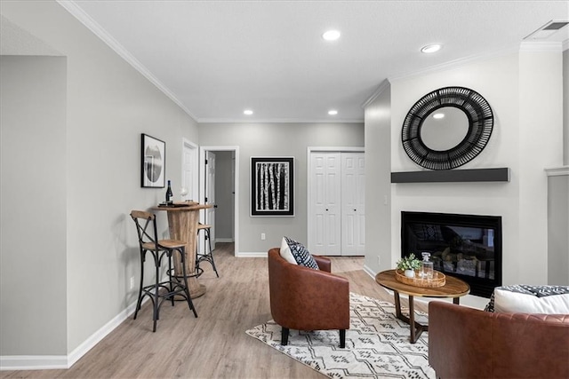 living room featuring ornamental molding and light wood-type flooring