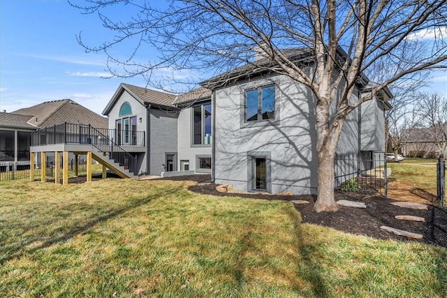 rear view of property with a sunroom and a lawn