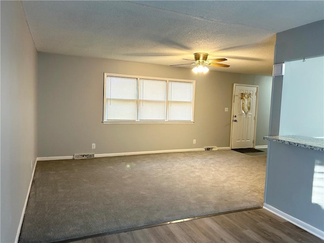 spare room featuring ceiling fan, a textured ceiling, and dark hardwood / wood-style flooring