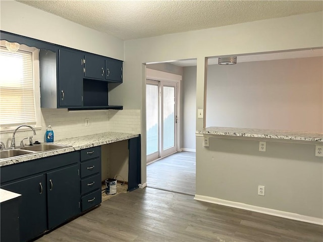 kitchen featuring a textured ceiling, dark hardwood / wood-style floors, tasteful backsplash, and sink