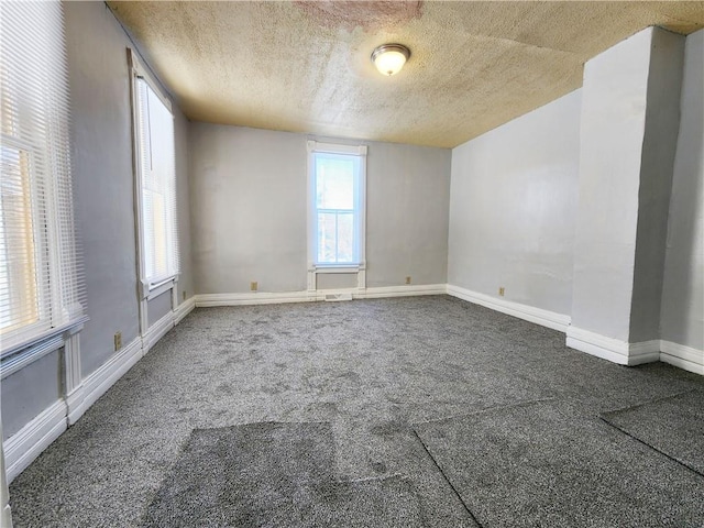 carpeted empty room with a textured ceiling