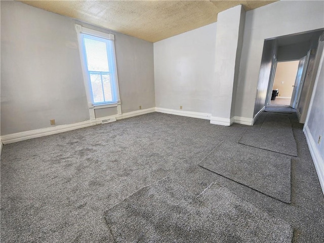 carpeted empty room featuring a textured ceiling