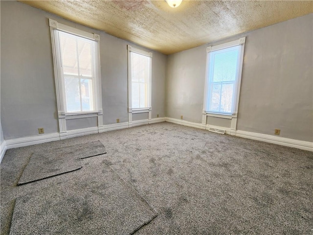 unfurnished room featuring a textured ceiling and carpet