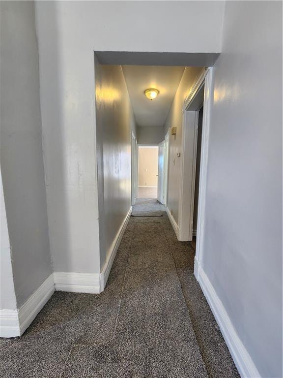 hallway with dark colored carpet