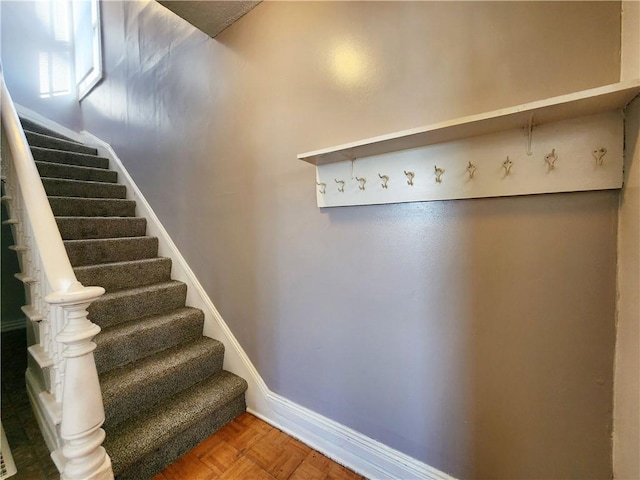 stairway featuring parquet floors