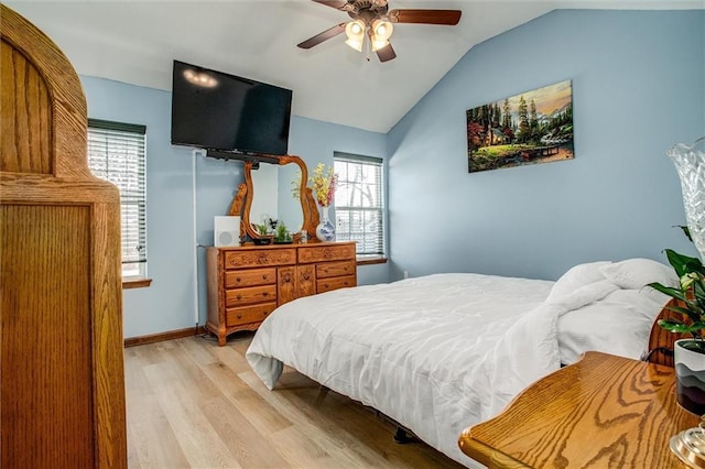 bedroom featuring multiple windows, ceiling fan, lofted ceiling, and light hardwood / wood-style flooring