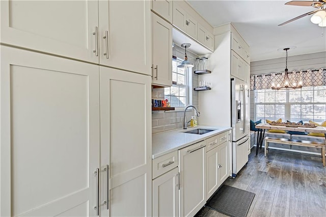 kitchen featuring sink, ceiling fan with notable chandelier, white cabinetry, and hardwood / wood-style floors