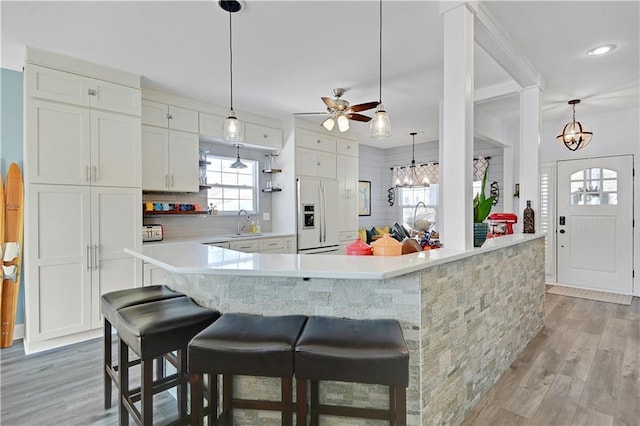 kitchen featuring light hardwood / wood-style floors, sink, white cabinets, and fridge with ice dispenser