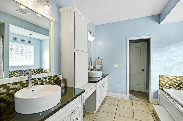 bathroom featuring vanity, a bathtub, decorative backsplash, and tile patterned flooring