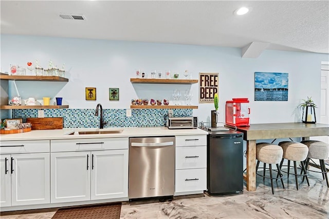 kitchen featuring sink, white cabinets, stainless steel dishwasher, and refrigerator