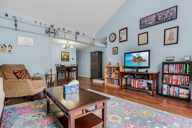 living room featuring high vaulted ceiling, a chandelier, and wood-type flooring