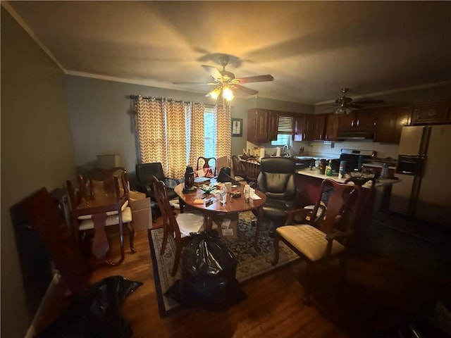 dining room featuring dark wood-type flooring, ornamental molding, and ceiling fan