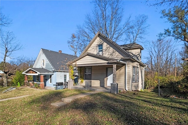 bungalow with covered porch and a front lawn