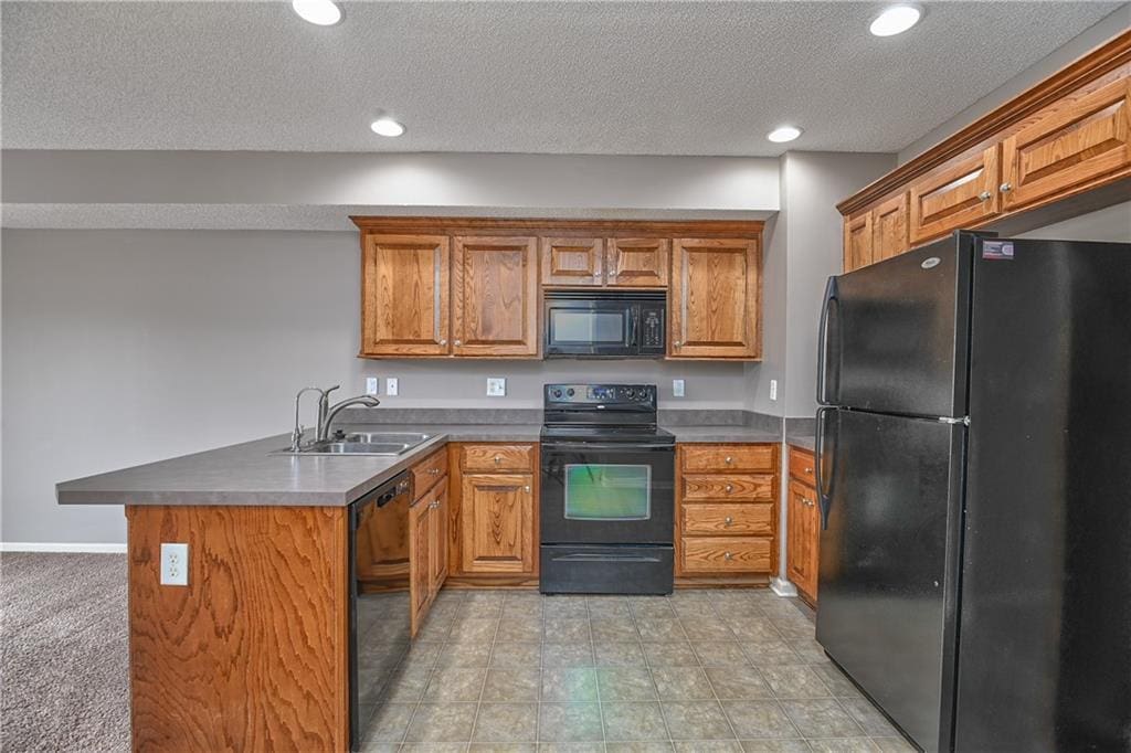 kitchen with sink, a textured ceiling, black appliances, and kitchen peninsula