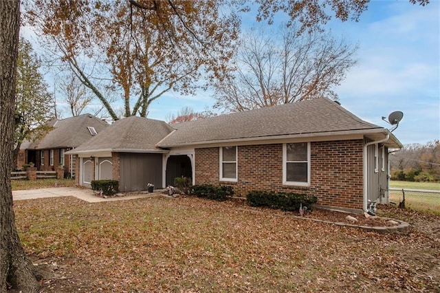 view of front facade with a garage, fence, brick siding, and driveway