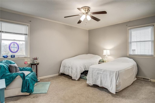 bedroom with multiple windows, carpet floors, baseboards, and crown molding