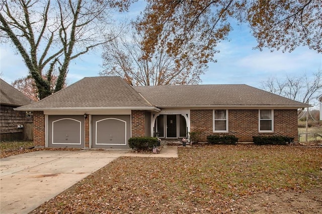 ranch-style house featuring concrete driveway, brick siding, and a garage