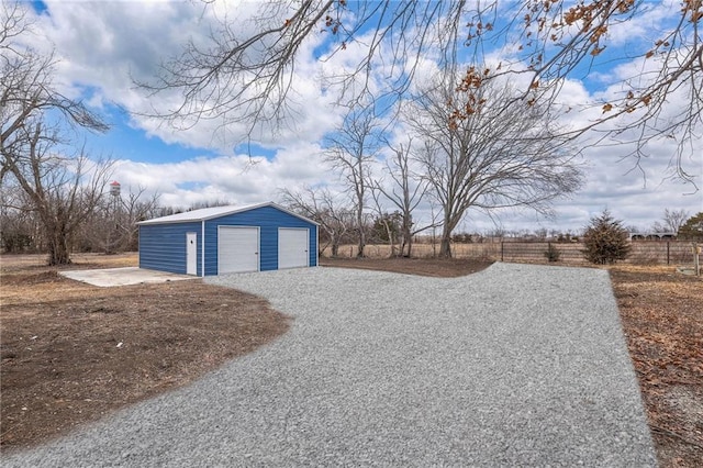 detached garage with fence and driveway