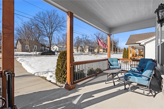 snow covered patio featuring a porch