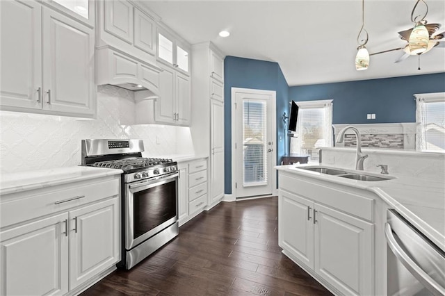 kitchen with sink, white cabinetry, hanging light fixtures, dishwashing machine, and gas range