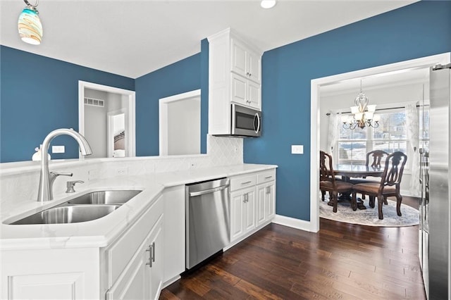 kitchen featuring white cabinets, a chandelier, sink, and stainless steel appliances