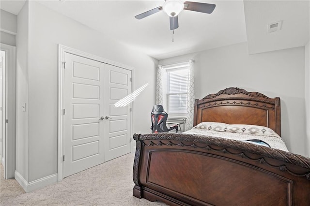 carpeted bedroom with ceiling fan and a closet