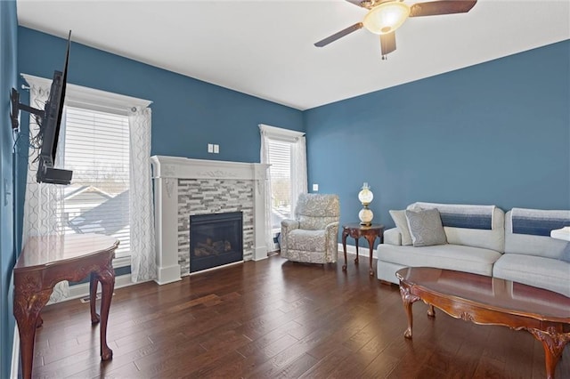 living room featuring ceiling fan, dark hardwood / wood-style flooring, a fireplace, and plenty of natural light