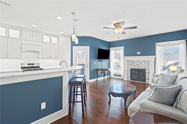 living room with ceiling fan, dark hardwood / wood-style flooring, a fireplace, and sink