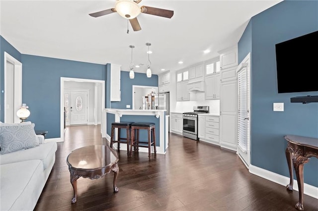 living room with ceiling fan and dark wood-type flooring