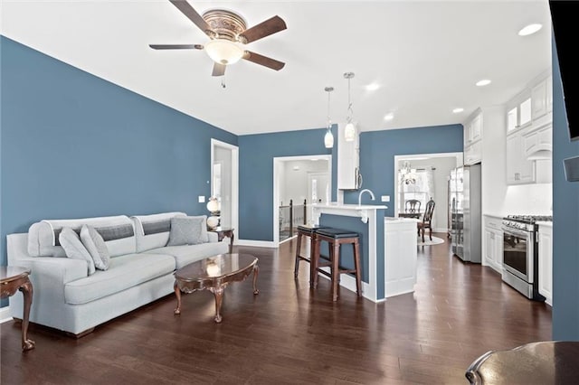 living room with ceiling fan and dark hardwood / wood-style floors