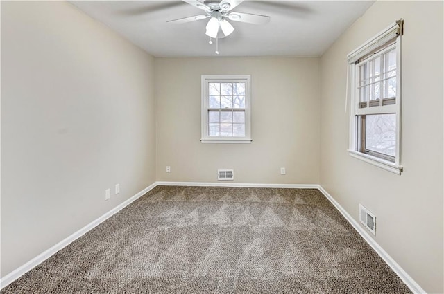 carpeted spare room featuring ceiling fan and a healthy amount of sunlight